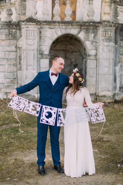 Feliz noiva recém-casada e noivo segurando artístico papercut cartas de amor — Fotografia de Stock