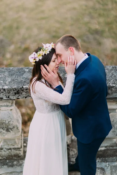 Ευτυχισμένος γαμπρός Αγκαλιάζοντας με χαριτωμένο λεπτή νύφη του, ενώ και οι δύο στέκονται σε αντίκες πέτρινες σκάλες. Προβολή υψηλής γωνίας — Φωτογραφία Αρχείου