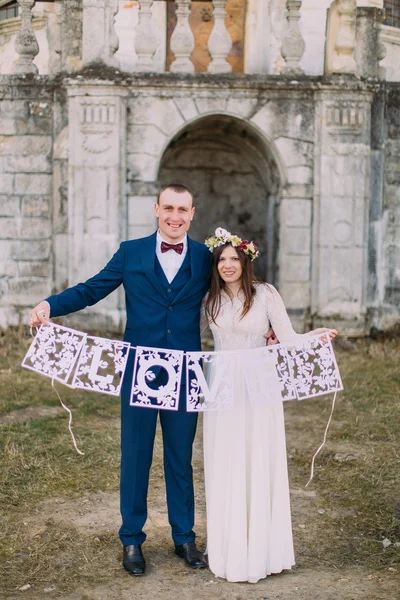 Веселые жених и невеста держат художественные буквы любви — стоковое фото