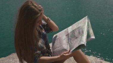 Genç genç kız dağ taş dağ Gölü ve eşlemek için arıyorum büyük su yüzeyi üzerine dayanıyor