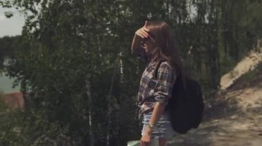 Onun harita ile kontrol ve aroiund yerel arazide seyir sırt çantası olan genç çekici turist kadın. Kamera etrafında dönüyor