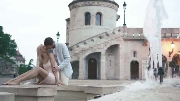 Молодая чувственная пара нежно целуется у белого мраморного фонтана в Париже — стоковое видео