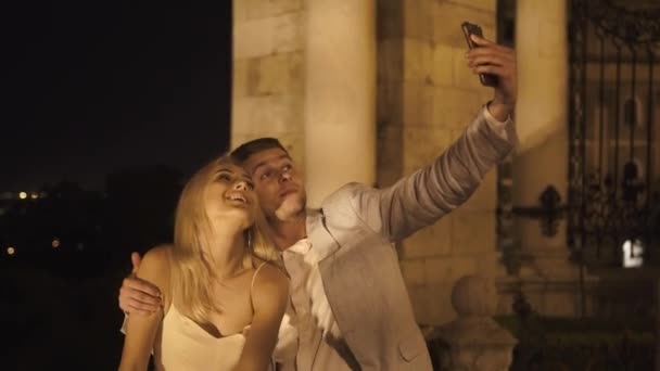 Affascinante coppia innamorata hanno una divertente passeggiata romantica e prendendo selfie in magnifico sfondo sfocato Budapest — Video Stock