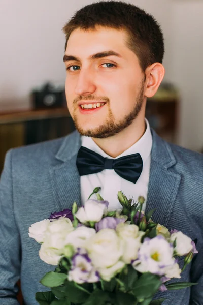 Elegante vestido guapo joven novio celebración de la boda ramo de rosas blancas — Foto de Stock