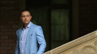 Şık ışık mavi takım tarafından korkuluk strone adımlarla yürüyen, yakışıklı genç