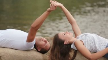 Güzel genç çift taş yakasında büyük Nehri yakınında döşeme ve eller tarafından dokunmadan