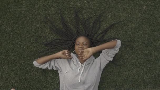 Belle jeune afro-américaine reposant sur l'herbe. Vue du dessus — Video