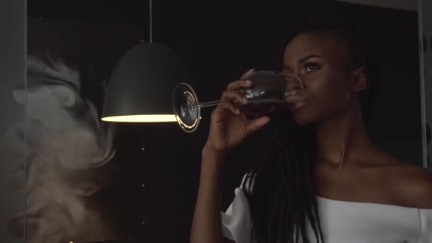 年轻美丽的非洲裔美国女性时尚模型从玻璃喝酒 — 图库视频影像