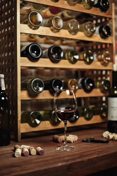 Bodega con botellas en estantes de madera — Foto de Stock