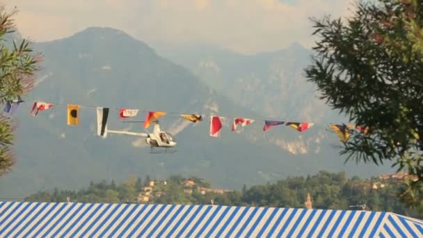 Летающий вертолет на фоне гор — стоковое видео