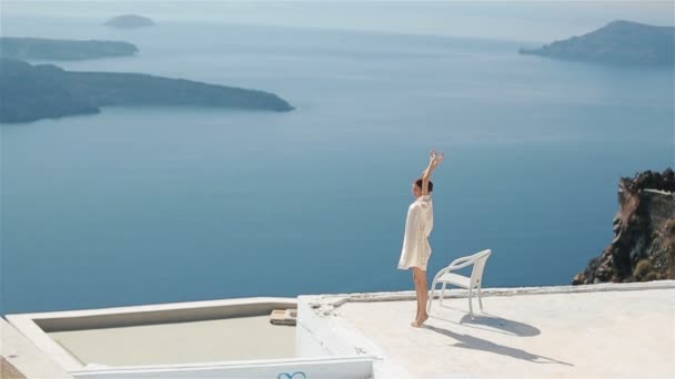 Beautiful sexy brunette bride in robe sitting at roof with sea and enjoying the amazing mountain view — Stock Video