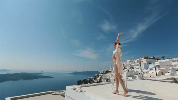 Piękna seksowna brunetka narzeczona w szatni tańce na dachu z morzem i górami w tle — Wideo stockowe
