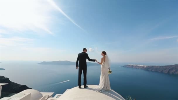 Счастливая супружеская пара целуется на террасе с морским фоном, Санторини крупным планом — стоковое видео