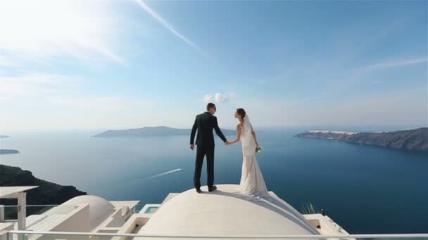 Felice coppia sposata baciare sulla terrazza con il fondo del mare, Santorini primo piano — Video Stock