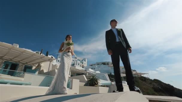 Feliz pareja casada encontrándose y besándose en la terraza con fondo de mar, Santorini primer plano — Vídeo de stock