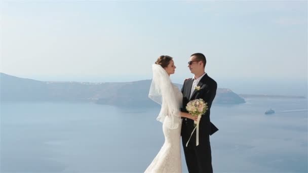 Glad gift par kyssas på terrassen med havet bakgrund, Santorini närbild — Stockvideo