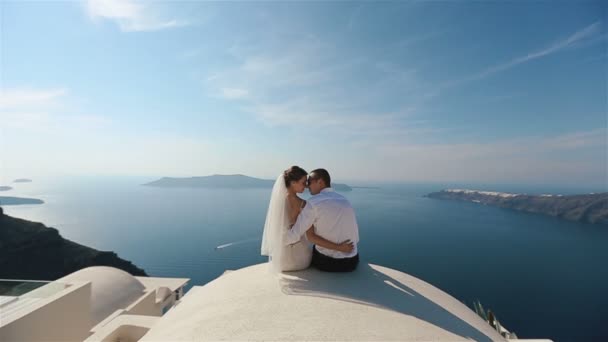 Glückliches Ehepaar sitzt und umarmt auf der Terrasse mit Meerblick, Santorini Nahaufnahme — Stockvideo