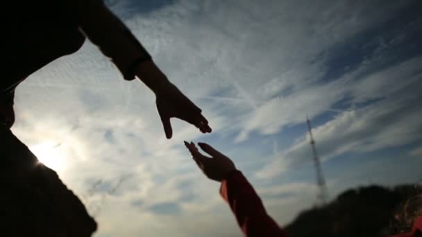 Ζευγάρι, κρατώντας τα χέρια στο ηλιοβασίλεμα silhouetted — Αρχείο Βίντεο