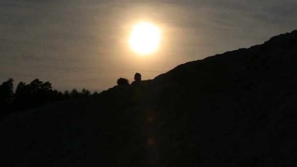 Couple romantique courant au sommet de la colline avec coucher de soleil béatifique sur un fond — Video