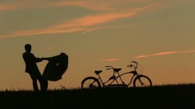 Günbatımı süre Tandem usulca elele bisiklet ile romantik çift. Yaz doğa arka plan güzel bulutlar gökyüzünde ile yakın çekim