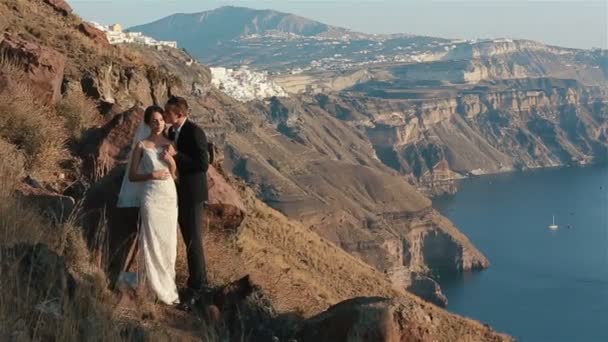 Evli çift, gelin ve damat, dağ volkan landcape Santorini, Yunanistan öpüşme kapat — Stok video