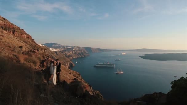 Gift par, bruden och brudgummen, kissing på berget vulkan landcape i Santorini, Grekland nära håll — Stockvideo