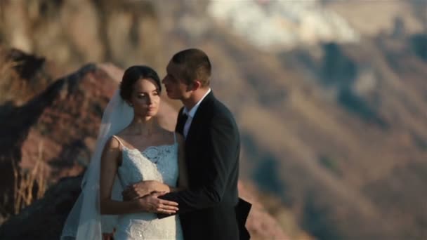 Casamento casal, noiva e noivo, beijando na montanha vulcão landcape em Santorini, Grécia close up — Vídeo de Stock