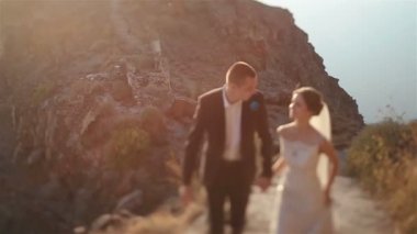 Evli çift, gelin ve damat, dağ volkan landcape Santorini, Yunanistan üzerinde yürüyen kapat