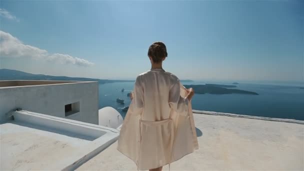 Szép szexi barna menyasszony-köntöst mozgó a tetőn, a tenger és a hegyek a háttérben — Stock videók