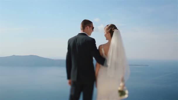 Happy married couple kissing on terrace with sea background, Santorini closeup
