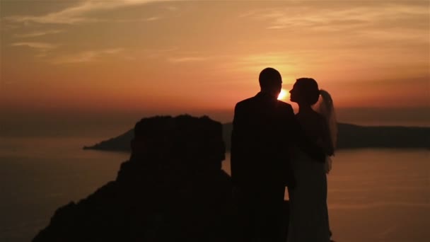 Magnifique mariée met doucement sa tête sur son marié épaule au coucher du soleil ciel arrière-plan — Video