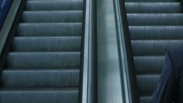 Hombre de confianza en traje negro subiendo a la escalera mecánica — Vídeos de Stock