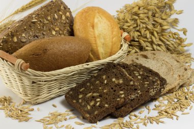 Çörek, ekmek, çörek bir sepet içinde tohumları ile. Siyah ekmek dilimlenmiş