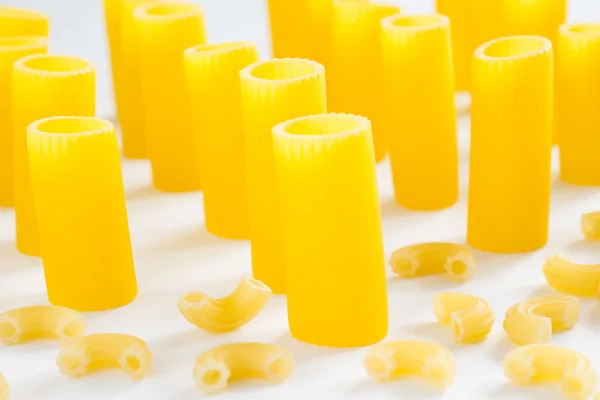 Pasta in the form of tubes and small horns on  white background — Stock Photo, Image