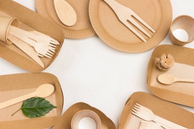 Tek kullanımlık karton tabaklar, tahta çatallar ve bıçaklar. Piknik için tek kullanımlık kağıt sofra takımı, fast food. Beyaz arka plan. Düz yatıyordu. Boşluğu kopyala
