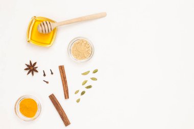 Bal ve kakule, tarçın çubukları ve zerdeçal. Soğuk algınlığı ve grip tedavisi. Geleneksel tıp konsepti. Sağlık hizmetleri. Uzayı kopyala Beyaz arka plan. Düz yatıyordu