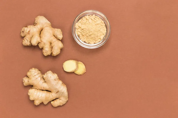 Raw ginger root and dry ginger on brown background. Products for immunity. Alternative cold and flu remedy.  Flat lay. Copy space