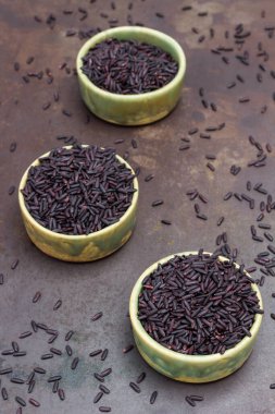 Yeşil seramik kaselerde siyah kahverengi pirinç. Paslı metal arka plan. Üst görünüm