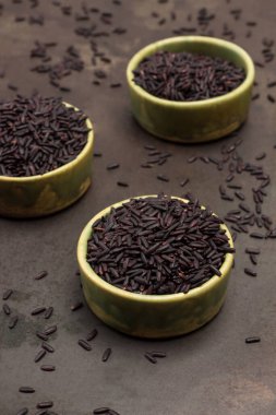 Yeşil seramik kaselerde siyah pirinç. Paslı metal arka plan. Üst görünüm