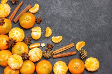 Mandalina ve baharatlar, yıldız anason, tarçın çubukları. Siyah arka plan. Uzayı kopyala Düz yatıyordu