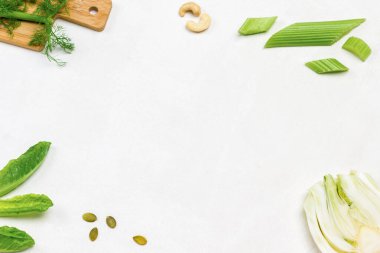 Düz kompozisyon ve beyaz arka planda taze yeşillikler. Mesaj için yer var. Sebze ve menü geçmişi. Düz yatıyordu