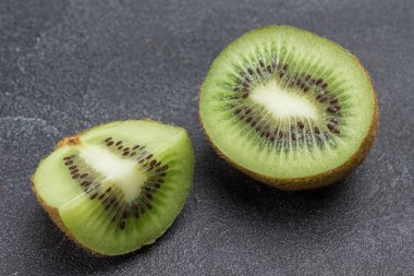 Doğranmış kivi meyvesi. Koca bir kivi meyvesi. Siyah arka plan. Üst görünüm