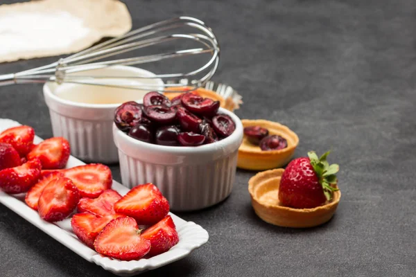 Berries Plate Tartlets Whisk Bowl Flour Paper Black Background Top — Stock Photo, Image