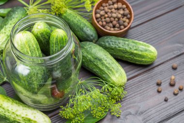 Cam kavanozda sarımsak, salatalık ve kiraz. Salatalık ve dereotu masada. Ev yapımı Fermantasyon Ürünleri. Düz yatıyordu