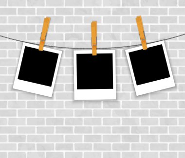 tuğla wal üzerinde clothespins ile ip üzerinde fotoğraf çerçeveleri