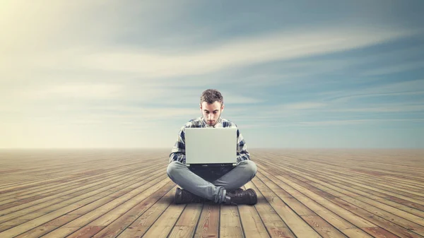 Bir ahşap zemin üzerinde oturan genç adam