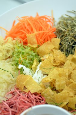 Özel yemek sırasında Çin yeni yılı Yusheng veya Yee Sang adı verilen