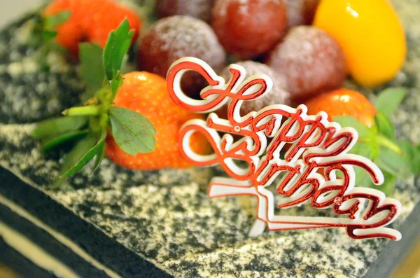 Happy Birthday candles on chocolate cake — Stock Photo, Image