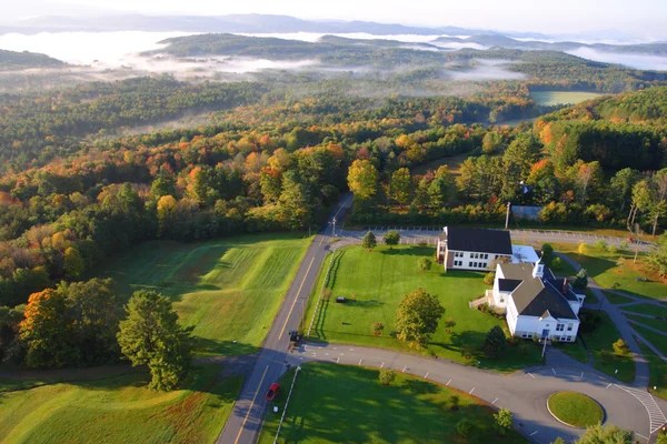 Uma vista aérea de um balão de ar quente flutuando sobre o lado do país de Vermont — Fotografia de Stock