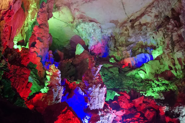 Beautiful illuminated multicolored stalactites from karst Reed Flute cave. Guilin Guangxi China — Stock Photo, Image